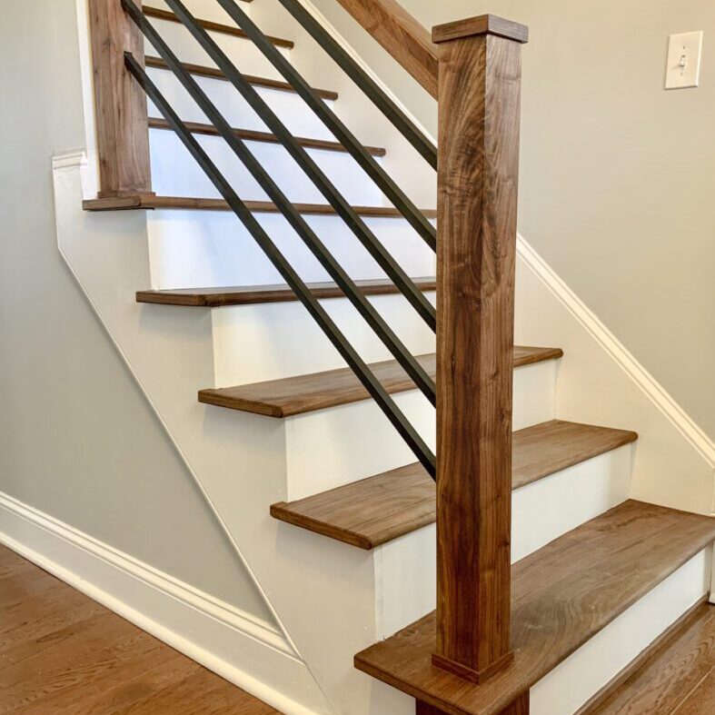 Wooden staircase with metal railing design.